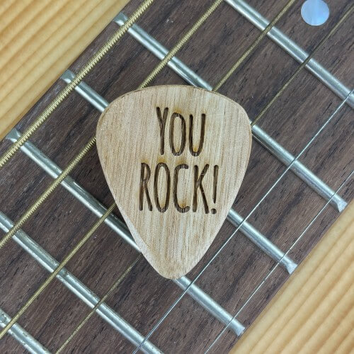 Engraved guitar pick with "your rock!" engraved.