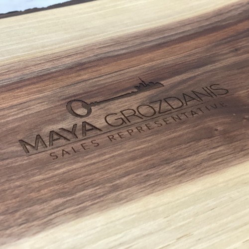 Realtor logo engraved on the back of a wholesale live edge charcuterie board.