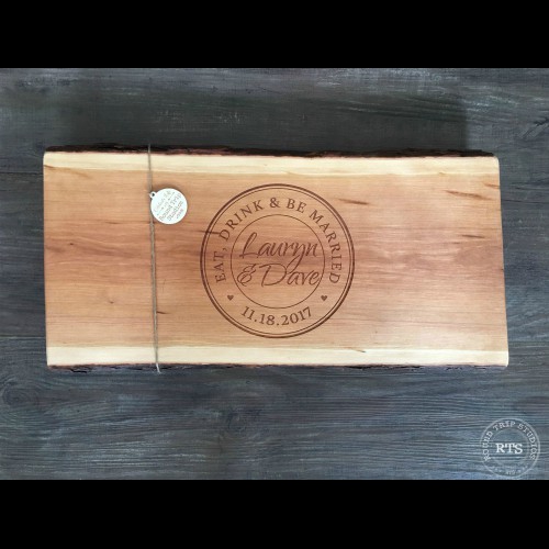 Live edge charcuterie board personalized with eat, drink and be married, and the couples names and wedding date engraved.