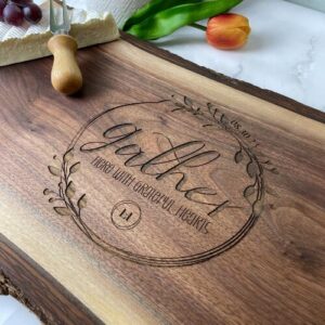 Live edge charcuterie board with the gather design and realtor logo engraved in the center.