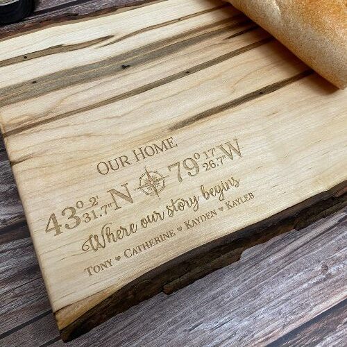 Charcuterie board designed with GPS coordinates and family names engraved in the corner.
