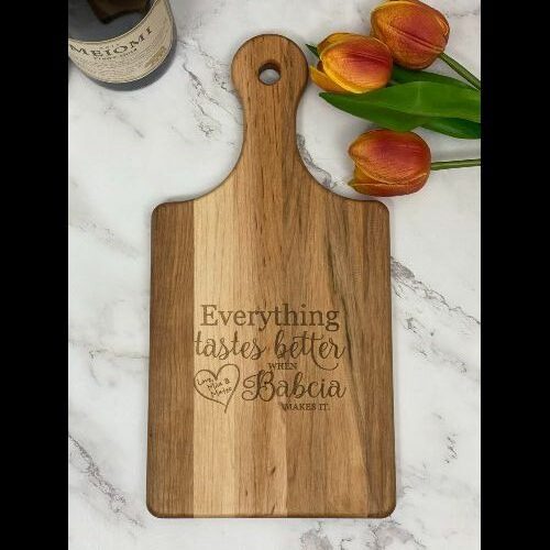 Paddle style cutting board with "everything tastes better when Babcia makes it."