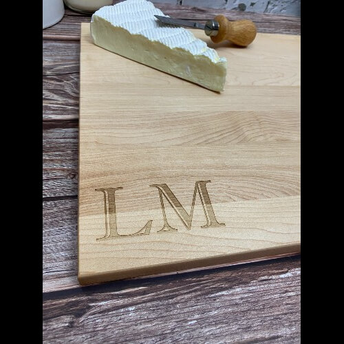 Close up of initials engraved on custom cutting board.