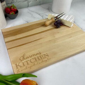 Wood cutting board with the kitchen design engraved in the corner.