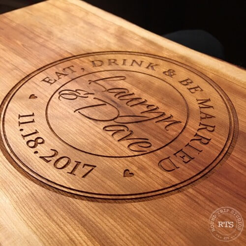 Charcuterie board personalized with a circular design of eat, drink, and be married.