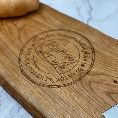LIve edge charcuterie board the name, date, and "together is a wonderful place to be" engraved on it.