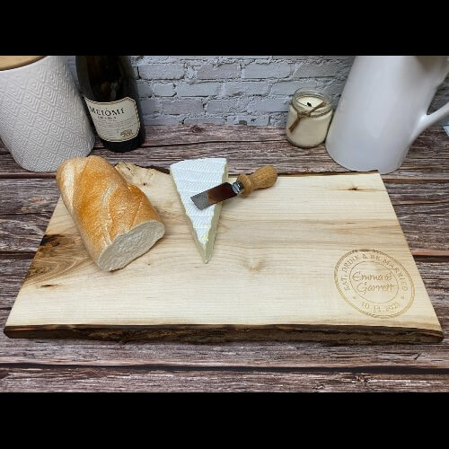Charcuterie board personalized for a wedding with an eat, drink and be married design engraved in the corner.
